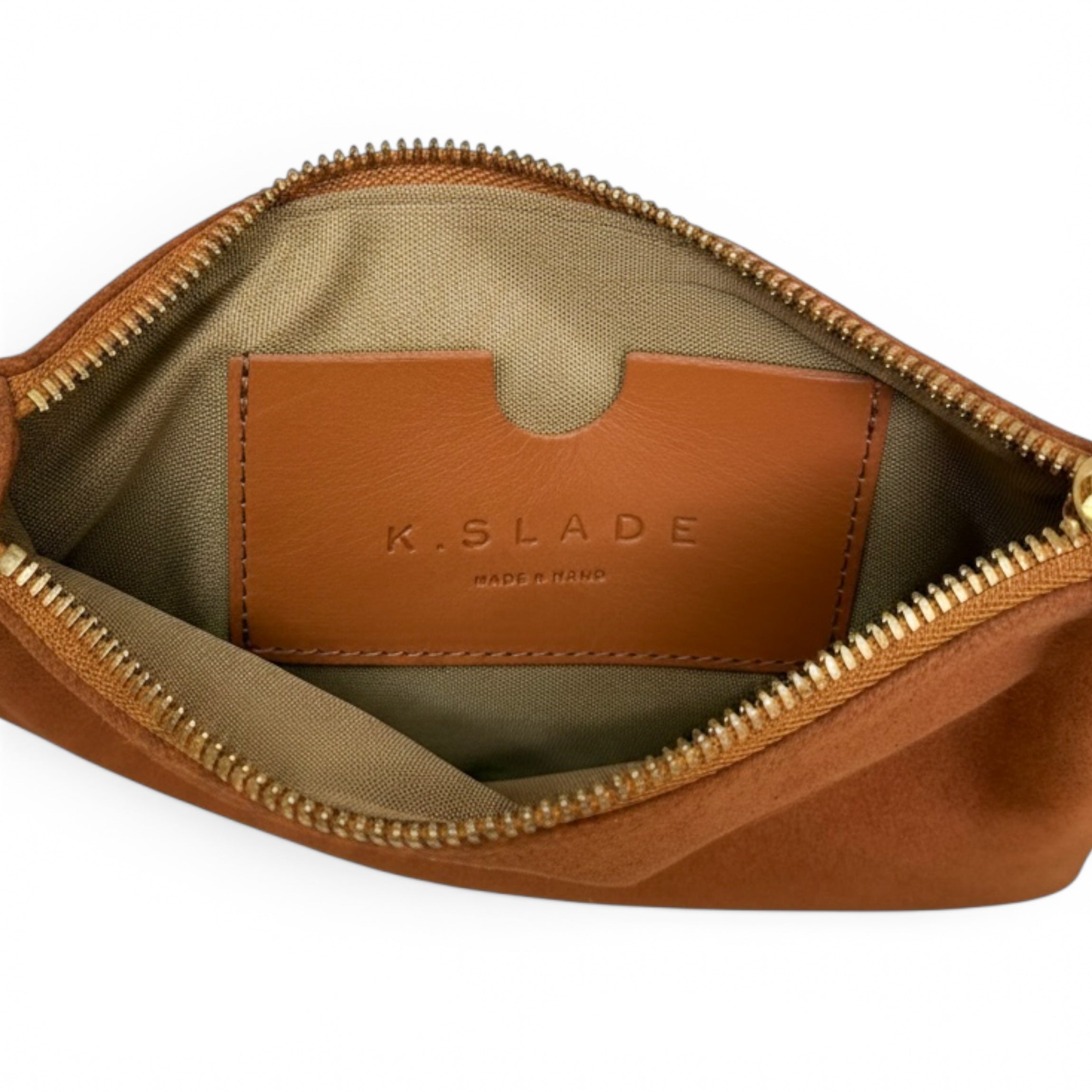 Open view of a brown leather pouch or cosmetic bag showing a tan interior lining with a leather brand patch that reads K.SLADE MADE IN NORD, on a white background.